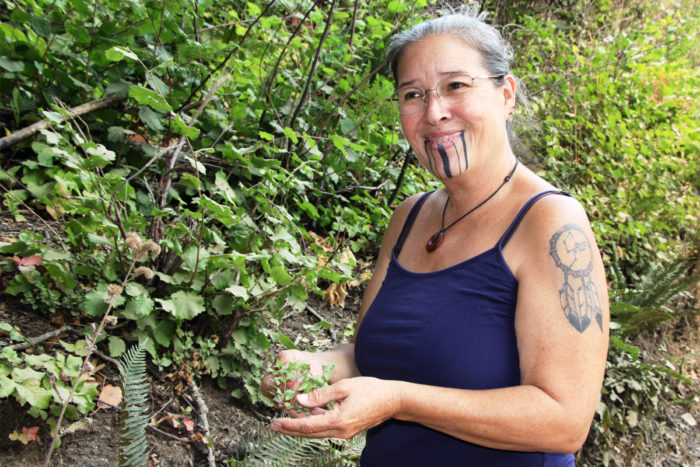 Elizabeth Azzuz, who works with the Cultural Fire Management Council, creates a wreath of tea vines growing in an area burned to improve hazel, a primary Yurok Tribe basket material.