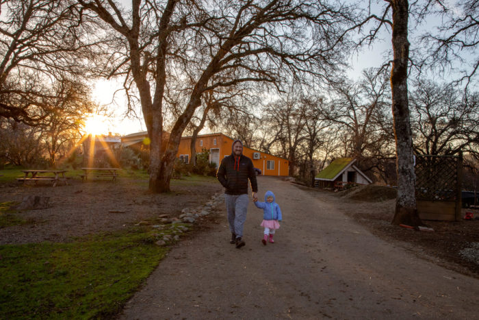 Chad Eatinger takes his daughter for an early morning walk. The Eatinger family has made three overnight “farmstays” to Long Dream Farm.