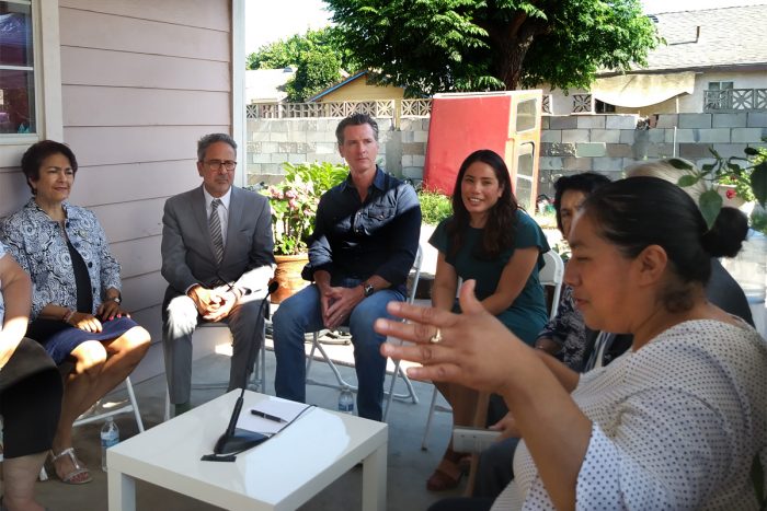 Governor Gavin Newsom (center) signs SB 200 at a home in the rural town of Tombstone in Fresno County with community residents, organizations, and State Senator Anna Caballero (left). (Photo courtesy of the Central California Environmental Justice Network).