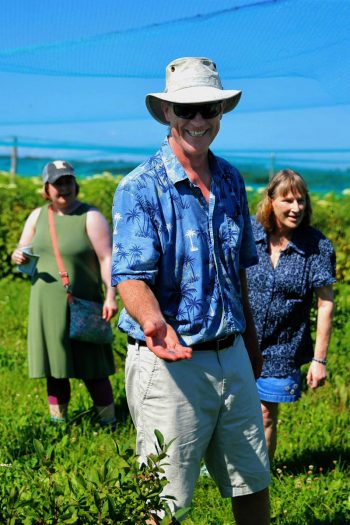 Jim Riddle offers a information and blueberries during a tour of Blue Fruit Farm. (Photo by Craig Johnson, courtesy of the Winona Daily News)