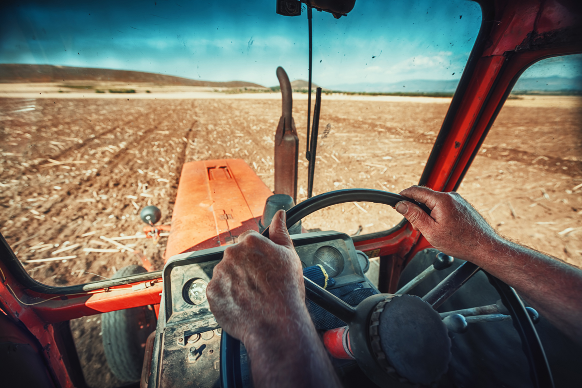 farmer driving a tractor on a large ranch