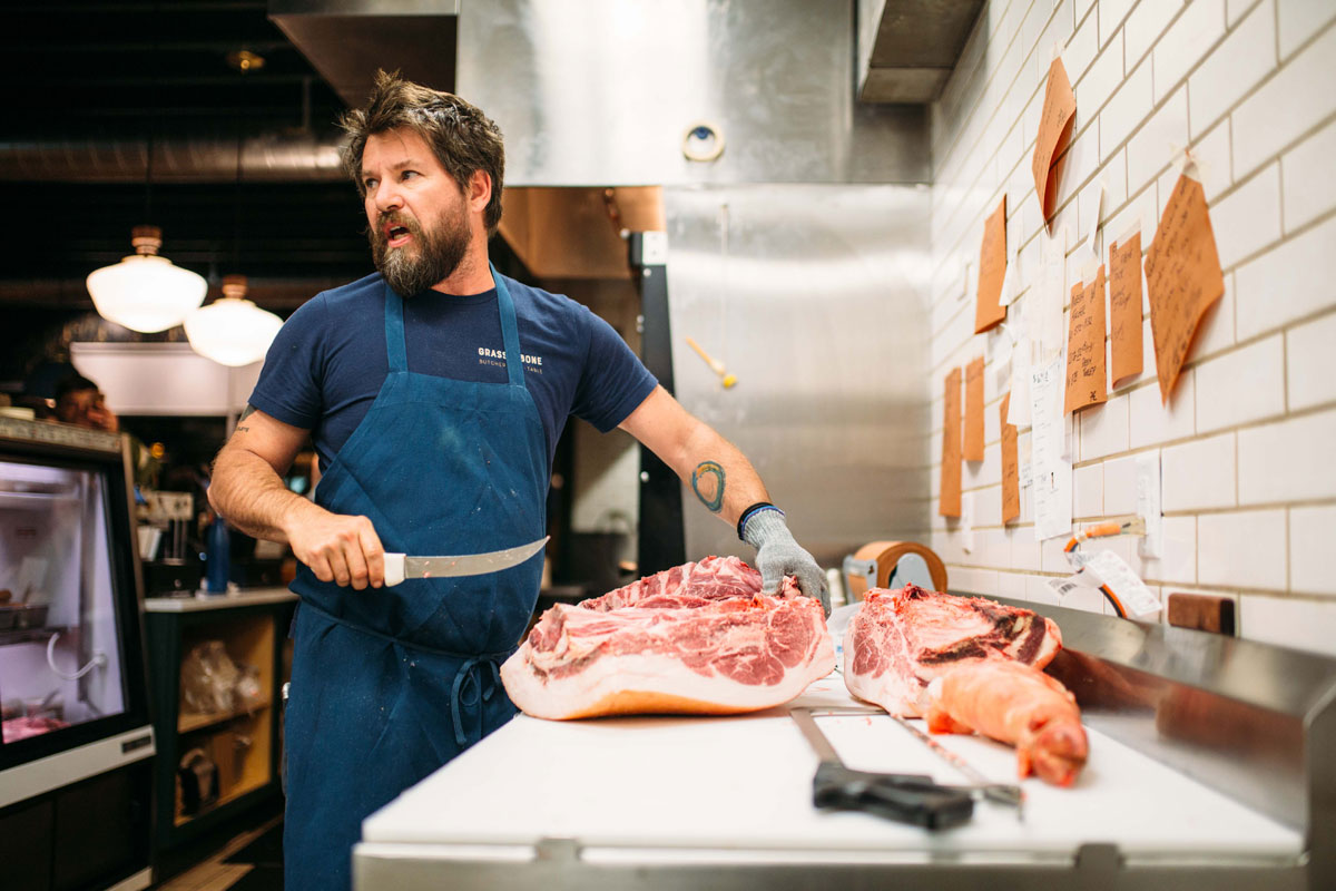 Grass & Bone's butcher, James Wayman, working in the kitchen.