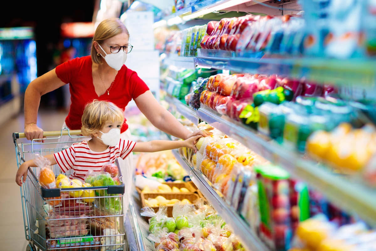 parent and child shopping for fresh produce while wearing masks and using pandemic ebt funds