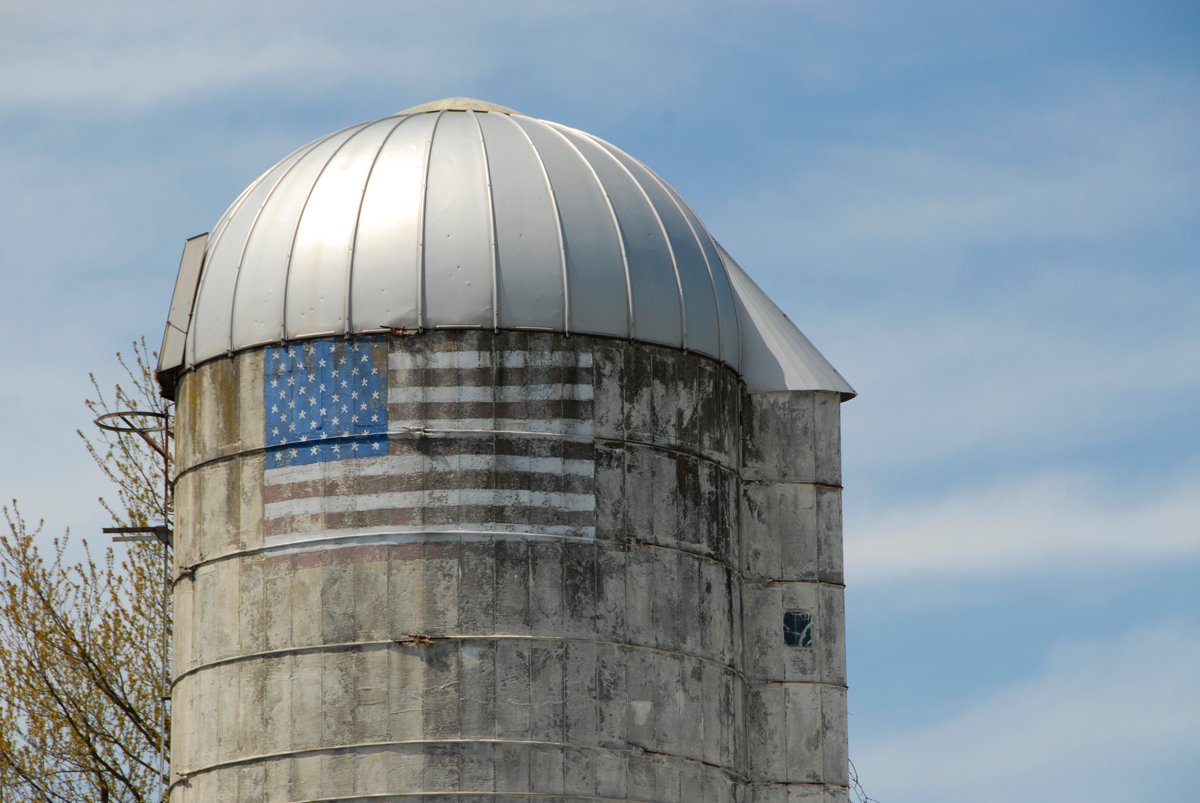 a weathered silo with a US flag painted on it