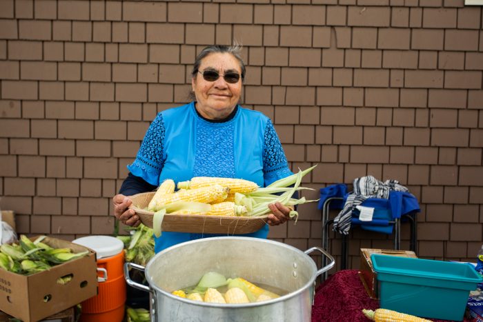 Doña Toña holding ears of freshly harvested corn to make elote. (Photo credit: Gorge Grown)