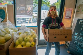 Melissa Madden bringing in a donated box of cucumbers.