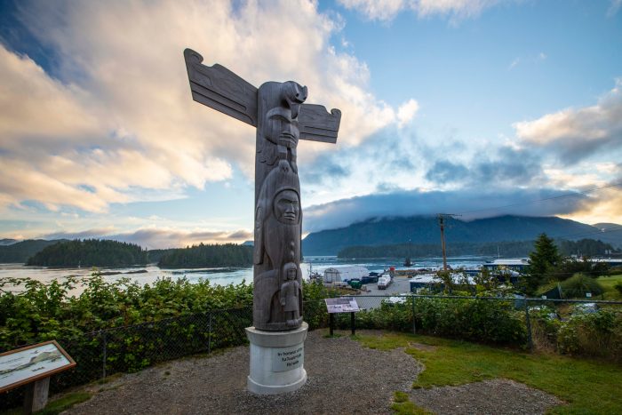 A totem pole carved by Joe David, sits on the waterfront in Tofino, BC in honor of the hereditary chiefs of the Tla-o-qui-aht First Nation. Cermaq's fish processing plant sits behind it on the waterfront.