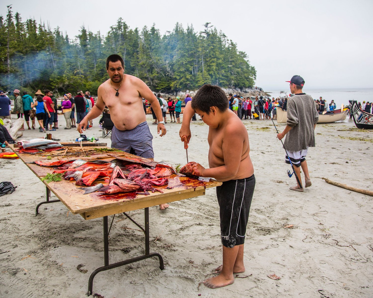 Two members of the Wuikinuxv First Nation prepare wild salmon to feed to guests to their territory during the annual Tribal Canoe Journey, which brings together First Nations from across the Pacific Northwest.