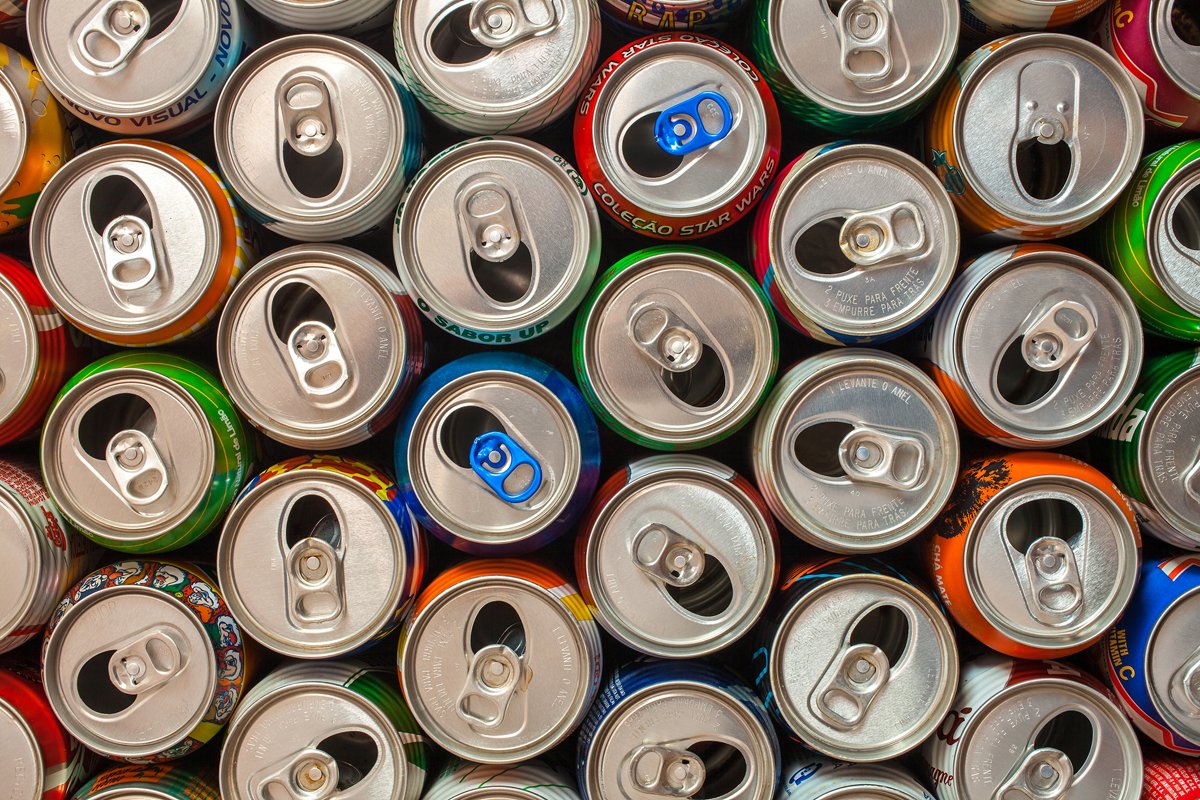 A photo of a bunch of soda cans from above, representing big food and junk food