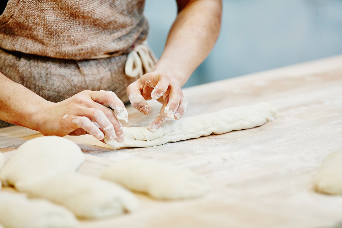 home baker kneading dough and shaping loaves of bread