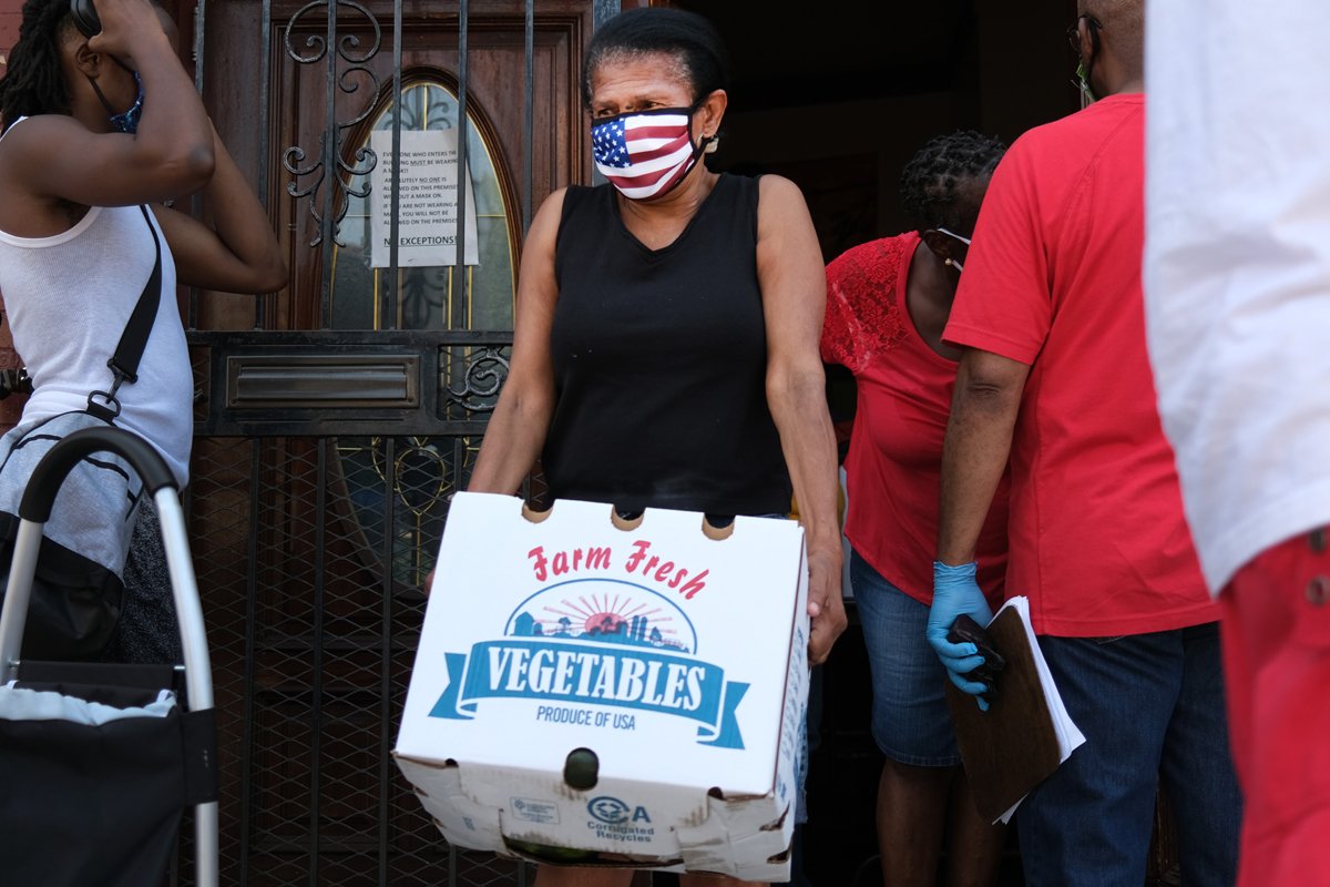 Food is distributed at the Ebenezer Seventh-day Adventist church on July 22, 2020 in the Brooklyn borough of New York City. The church distributes hundreds of packages of food every Wednesday. While many New York neighborhoods have long depended on charities, food banks and nonprofits to meet their nutritional needs, the Covid-19 pandemic has only multiplied the number of residents experiencing food insecurity. Across the city groups that serve those in need are seeing a huge increase in clients. According to the mayor’s office, an estimated 2 million people are currently food insecure in New York City, which is up from 1 million people before the pandemic. (Photo by Spencer Platt/Getty Images)