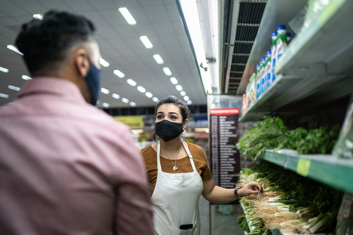 a dietician helps a shopper pick the healthiest food at a supermarket