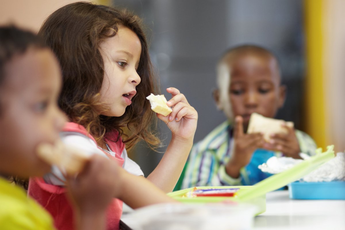 three children eating federally subsidized school meals