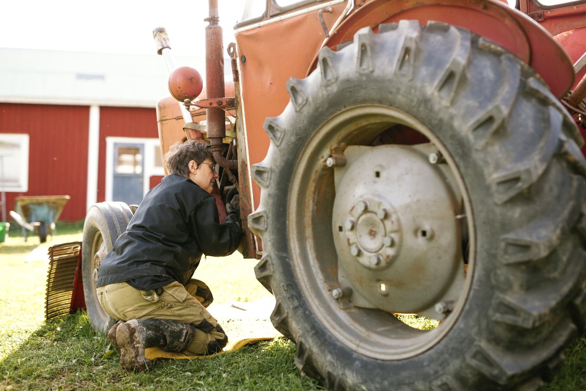 A Woman is trying to repair her John Deere tractor