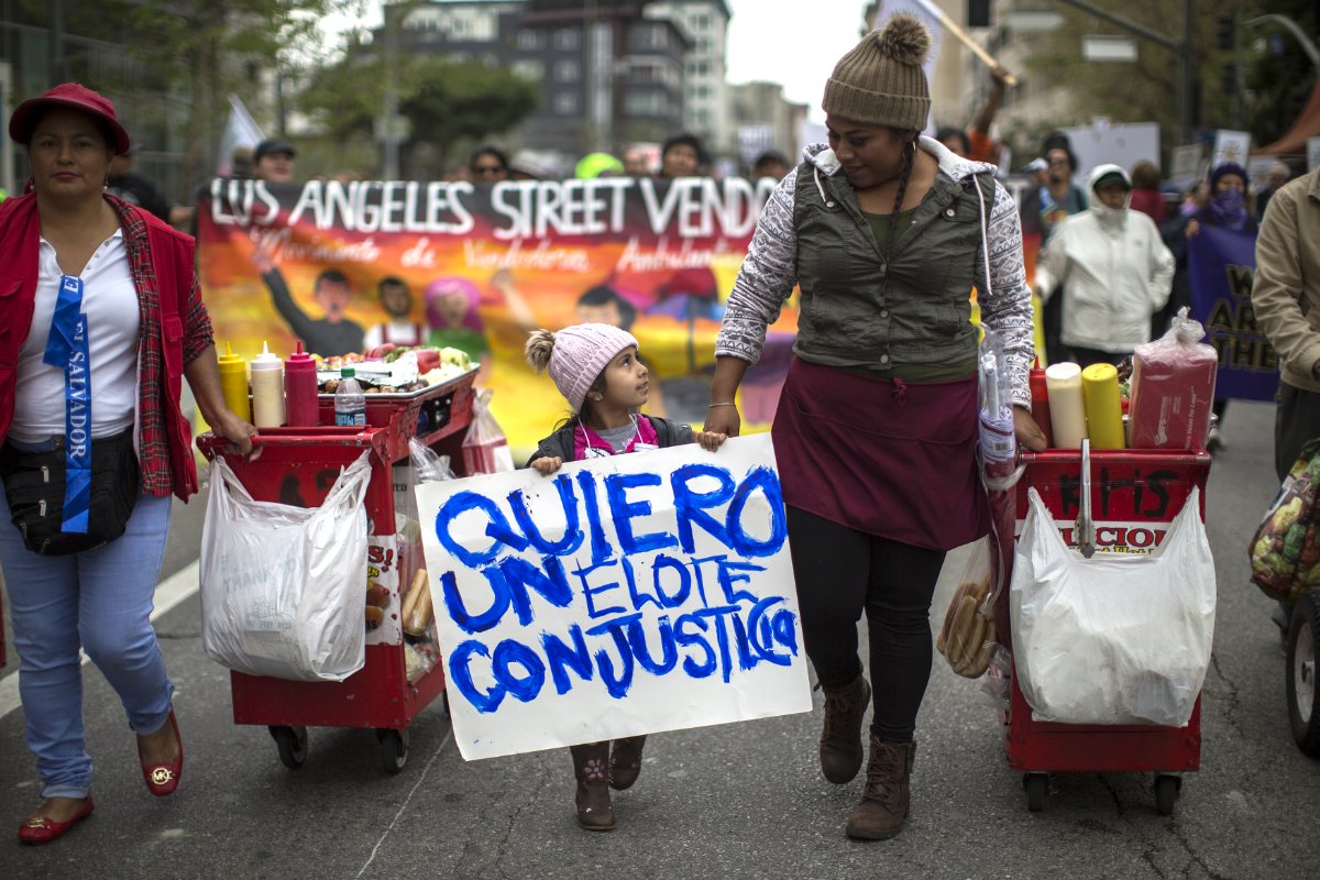 A girl walks with street food vendors calling for legalization of their trade during a march on May Day, on May 1, 2018 in Los Angeles, California. David McNew/Getty Images)