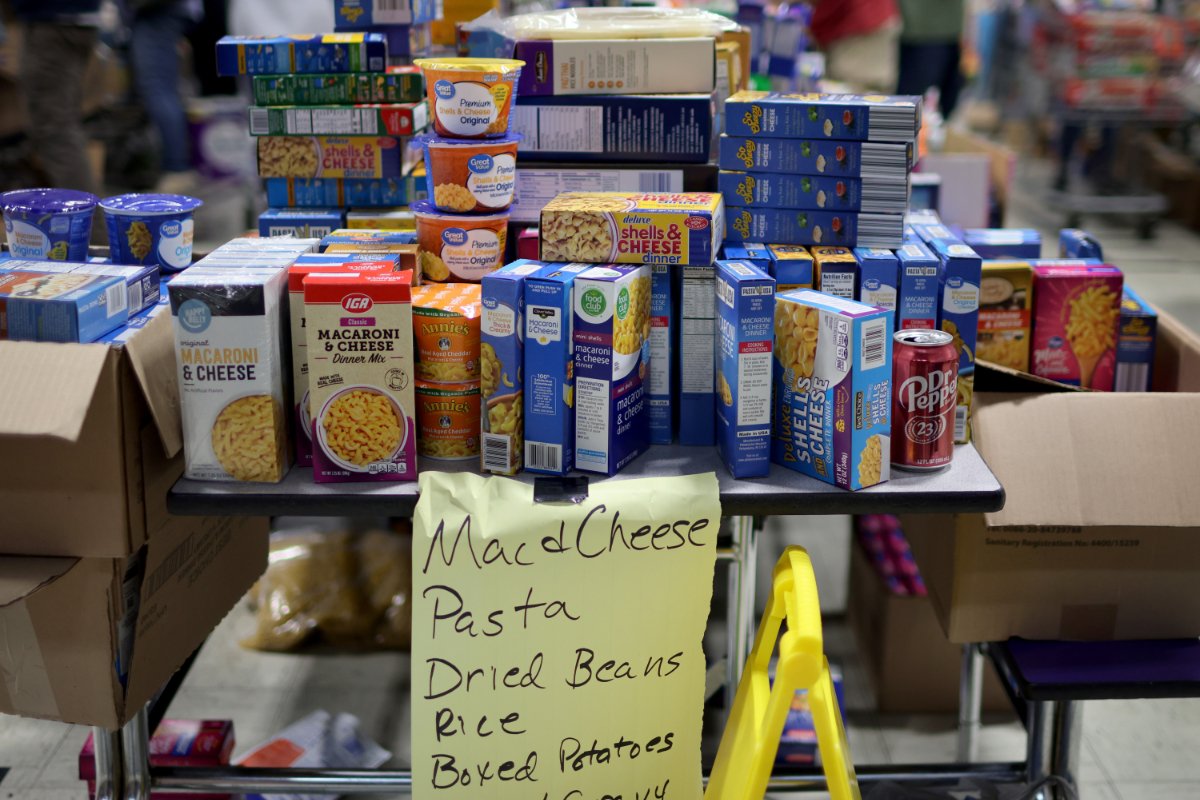 Food donations are piled up on a table in the wake of a natural disaster.