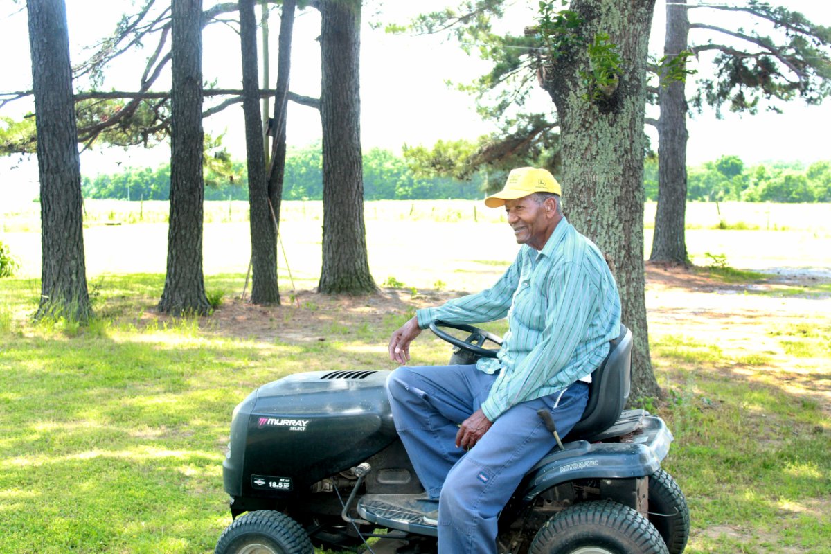 Arkansas farmer Clem Edmonds sits on his riding mower in Cotton Plant, Arkansas. (Photo by Wesley Brown)