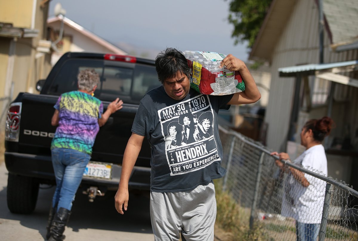 A resident of Porterville, California, carries a case of bottled water for use at home. (Photo credit: Justin Sullivan, Getty Images)