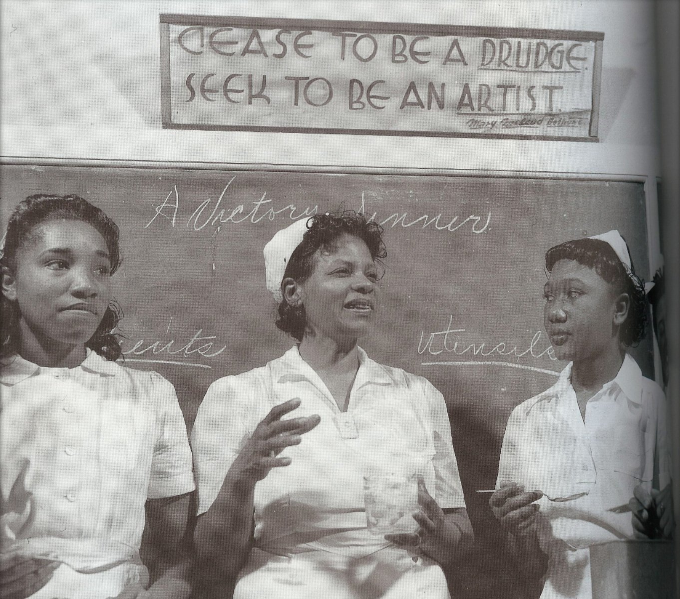 A group of Black women lead a cooking class; a banner above the chalkboard reads, 