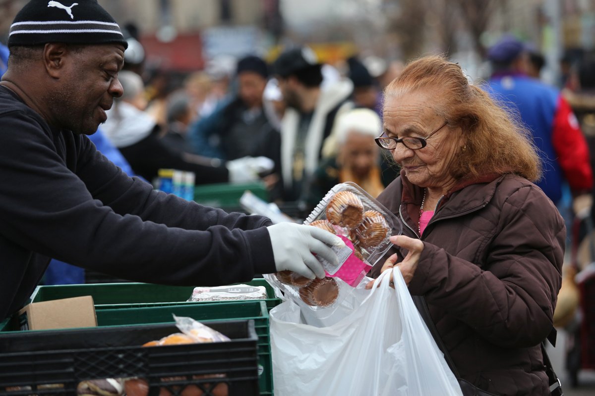 A woman holds a bag of pears as she waits in line to receive free food at the Richmond Emergency Food Bank. (Photo by Justin Sullivan/Getty Images)