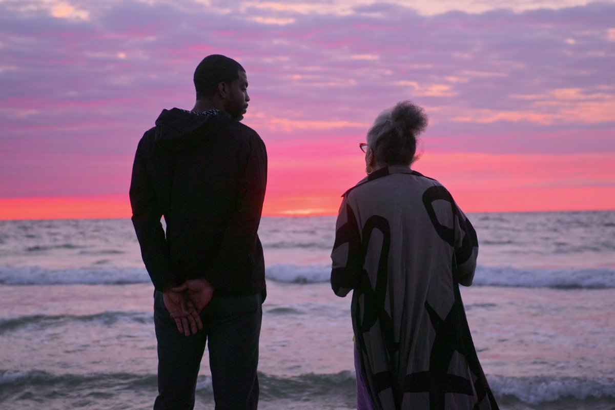 Stephen Satterfield and Jessica B. Harris watching the sunset at the beach, in a still from Netflix's High on the Hog Season 2. (Photo courtesy of Netflix)