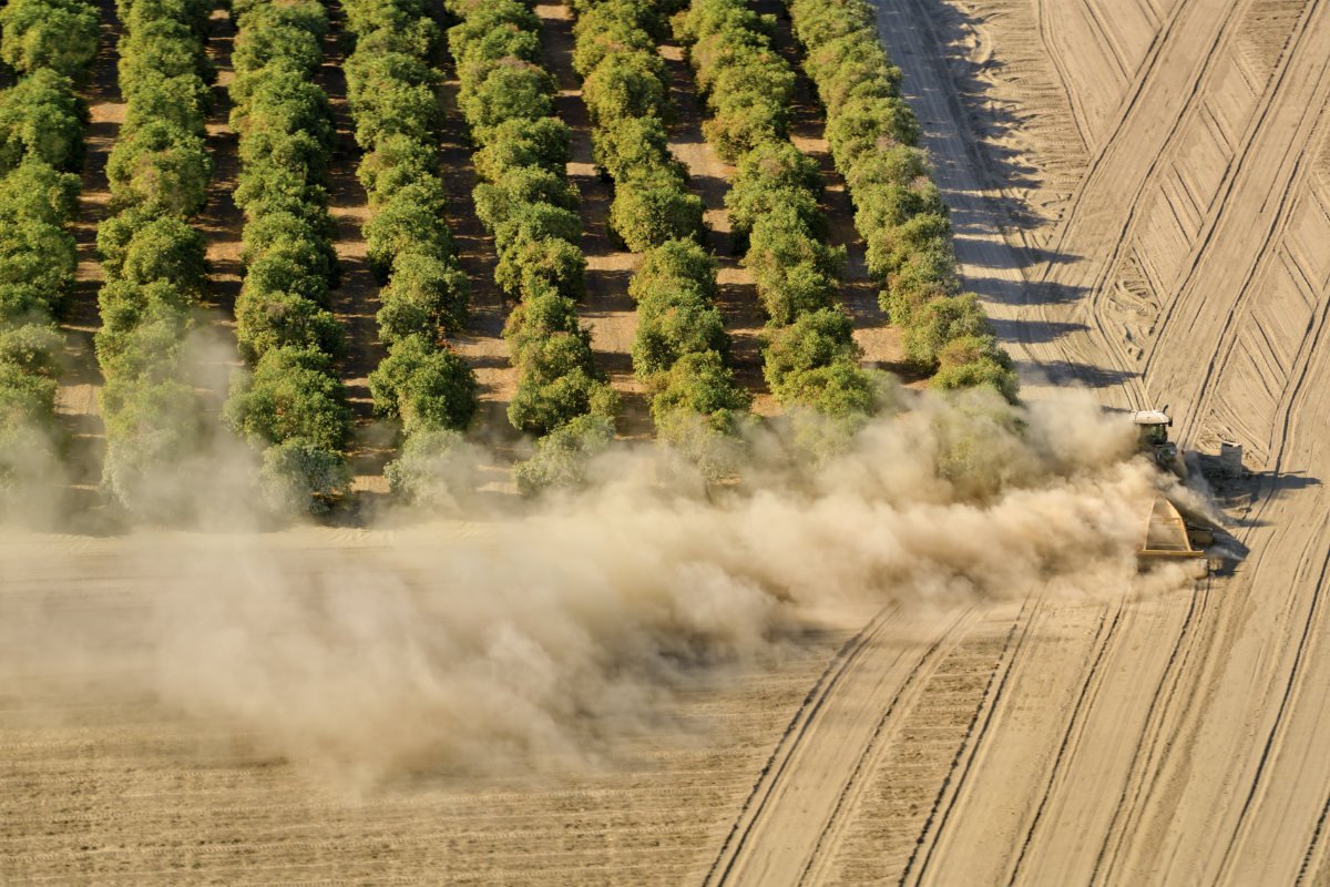 A tractor in california is kicking up dust working in the fields, adding particulate matter to the air and lowering air quality