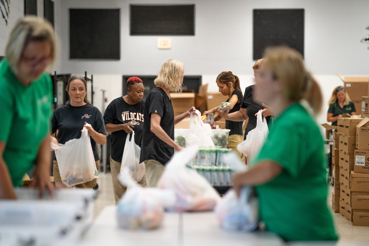 Cafeteria workers at Lockerman Middle School work in an assembly line to pack bags filled with three days of meals. (Photo credit: Colin Marshall)