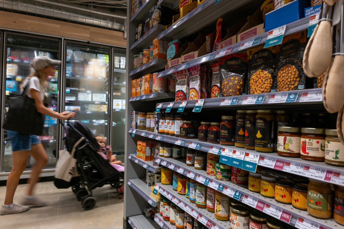 A parent shops for groceries with a child in a stroller in August 2024 in New York City. (Photo credit: Spencer Platt, Getty Images)