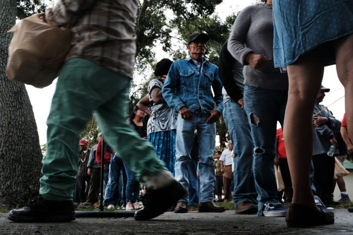 People wait in line for food at the annual Thanksgiving in the Park gathering where residents of the farm worker community of Immokalee are provided with a free Thanksgiving meal. (Photo by Spencer Platt/Getty Images)