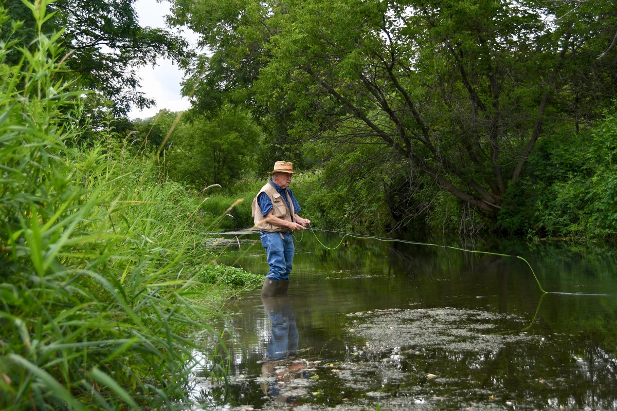 Fisherman Ted Fleener hunts for trout in Bloody Run Creek. (Photo credit: Larry Stone)